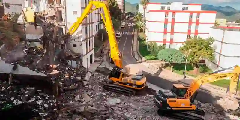 escavadoras destruyendo casa