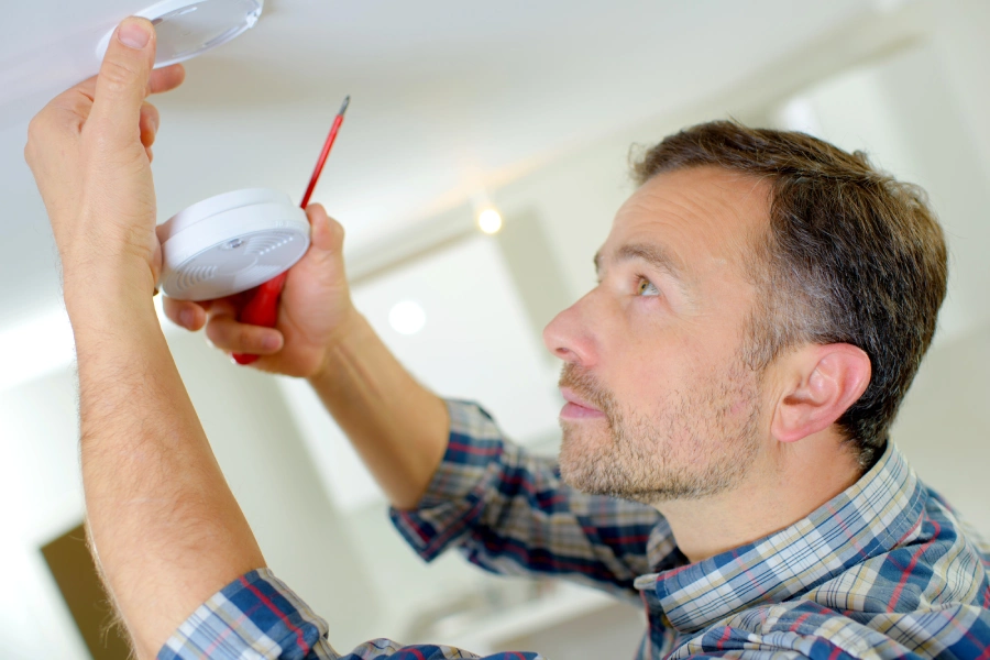 hombre-instalando-un-detector-de-humo